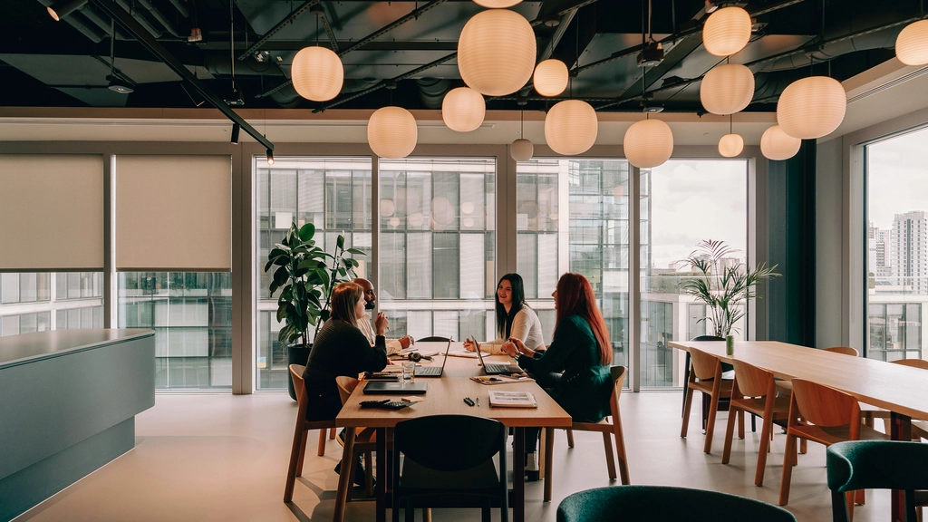people sitting at a table under round overhead lights